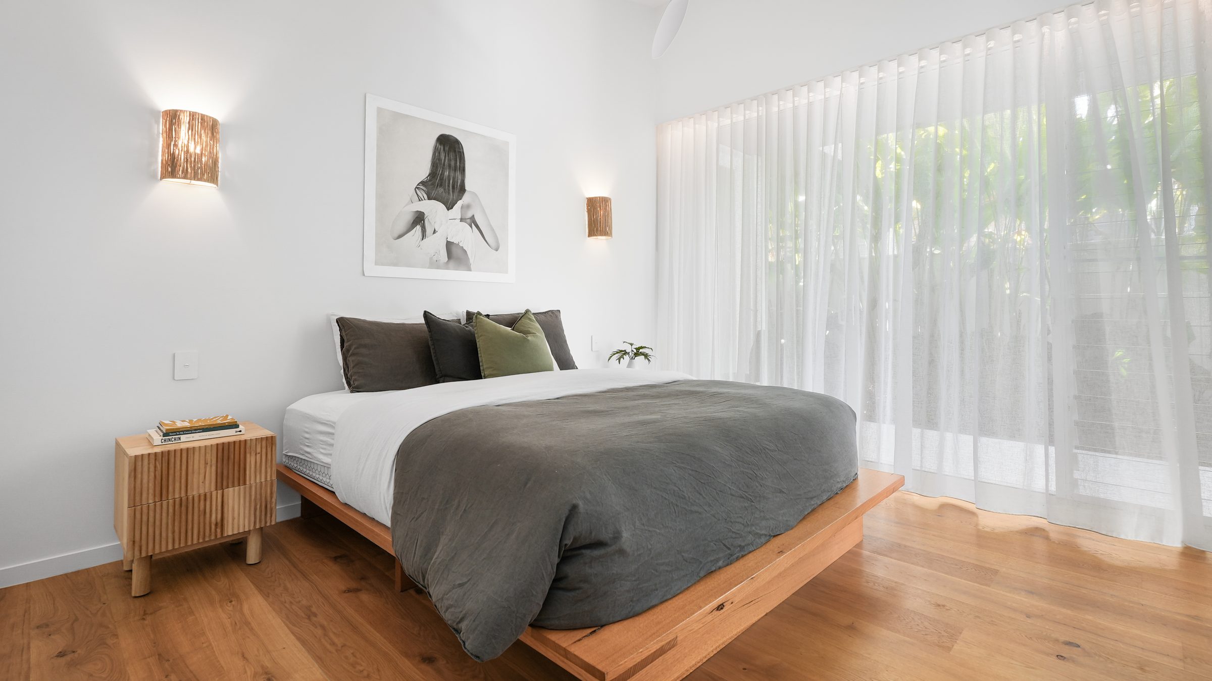 Master bedroom with painted portrait and oak floor