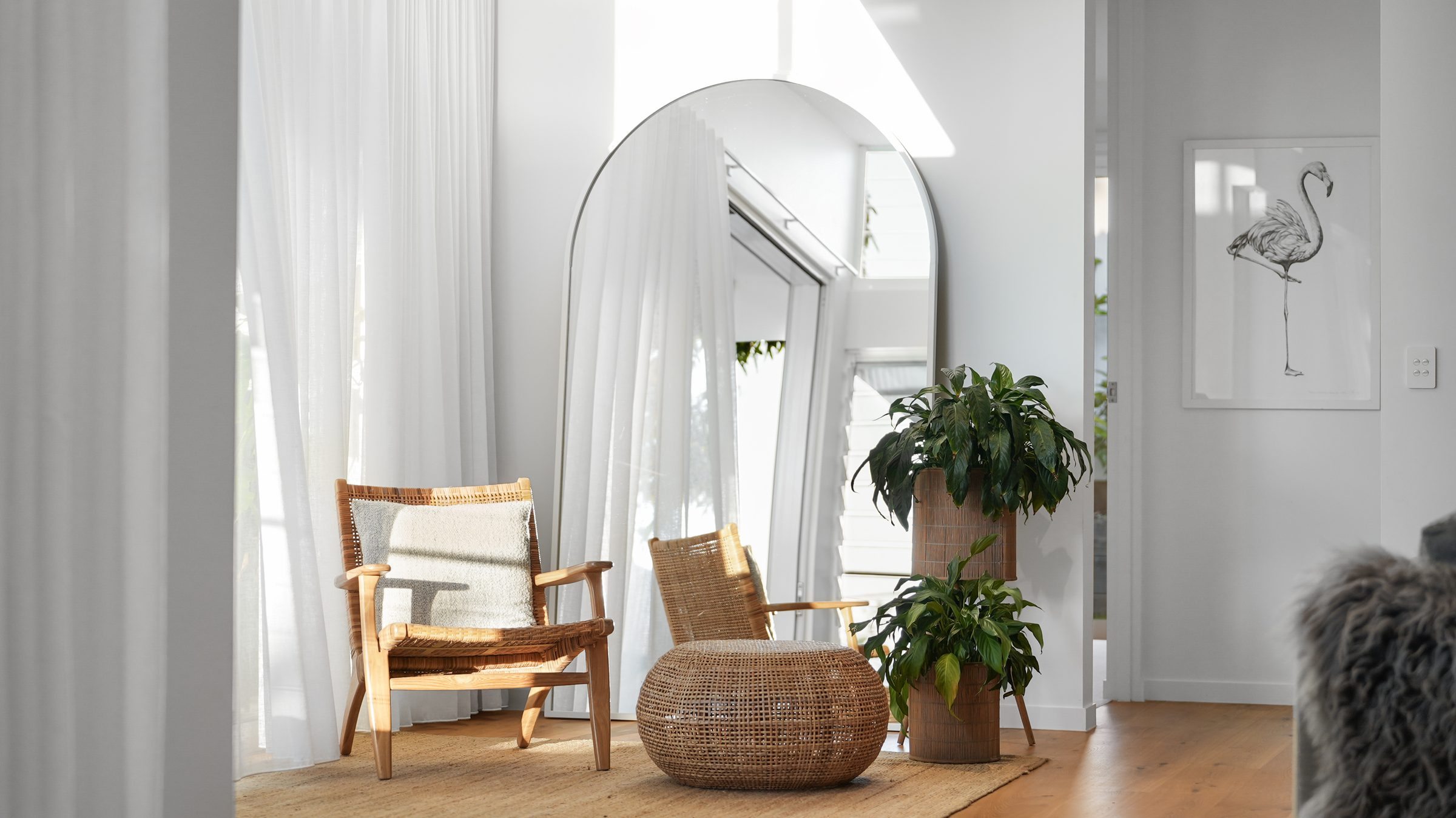 Arched mirror with rattan chair and plants
